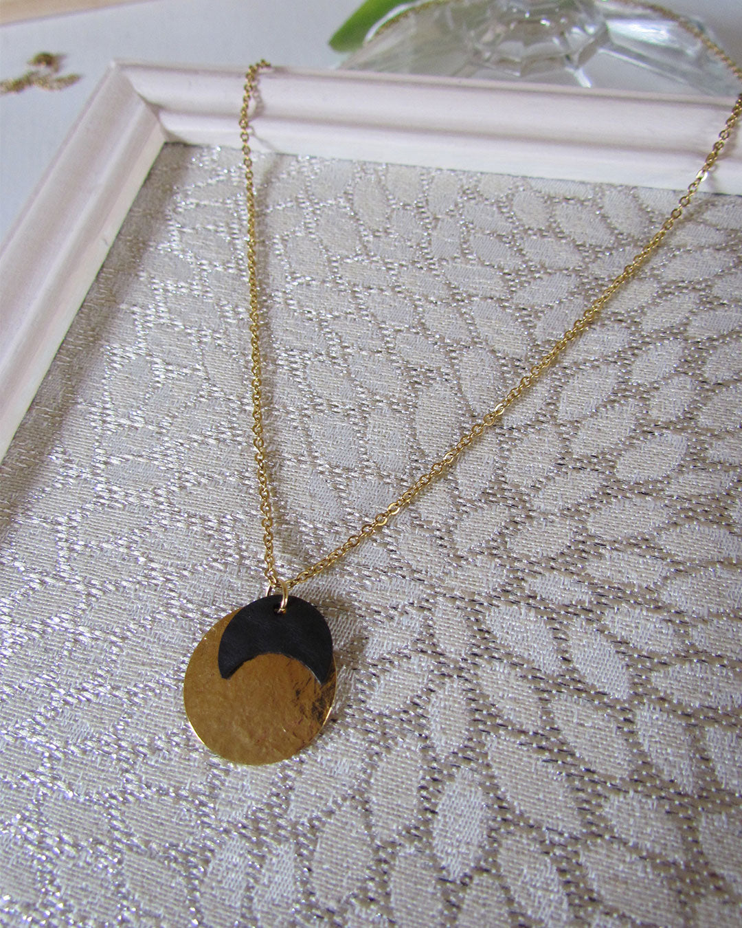 Collier or et noir comme une petite médaille à lune noire