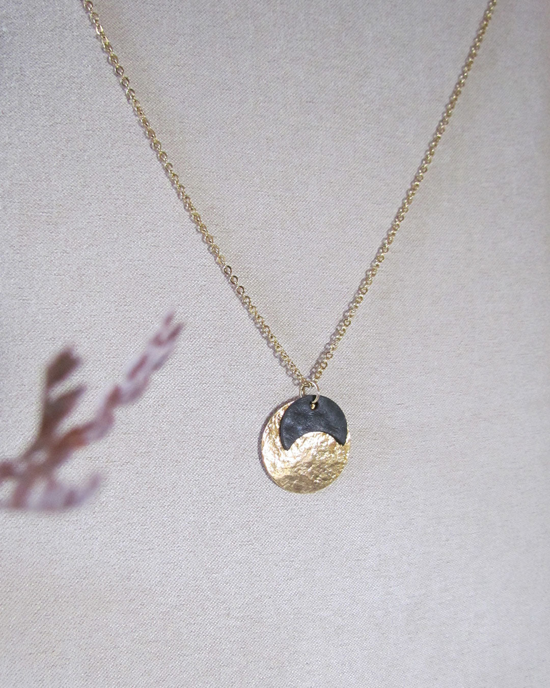 Collier or et noir comme une petite médaille à lune noire