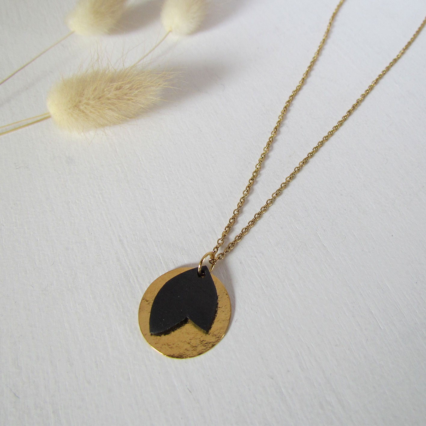 Collier or et noir comme une petite médaille avec une feuille upcyclée