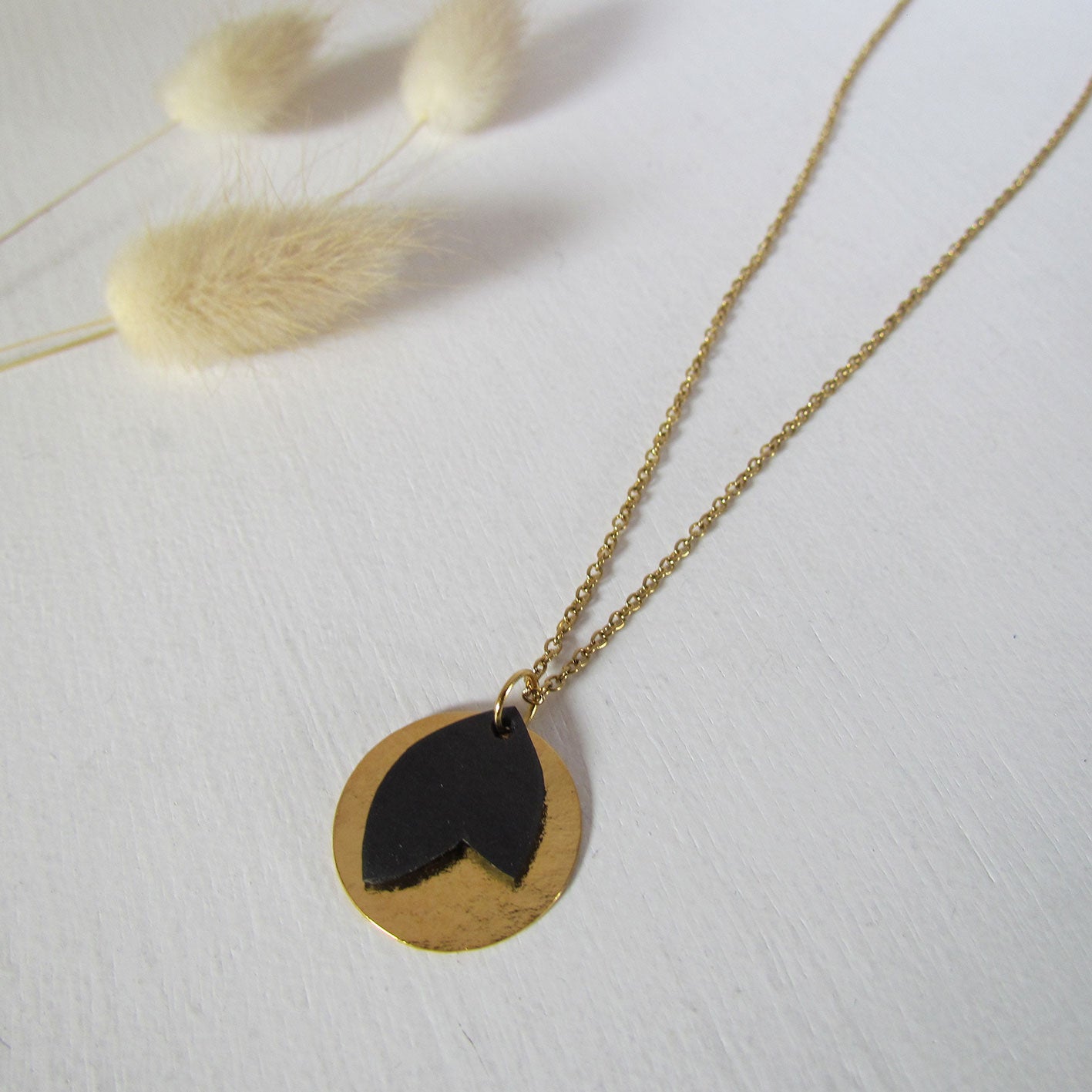 Collier or et noir comme une petite médaille avec une feuille upcyclée