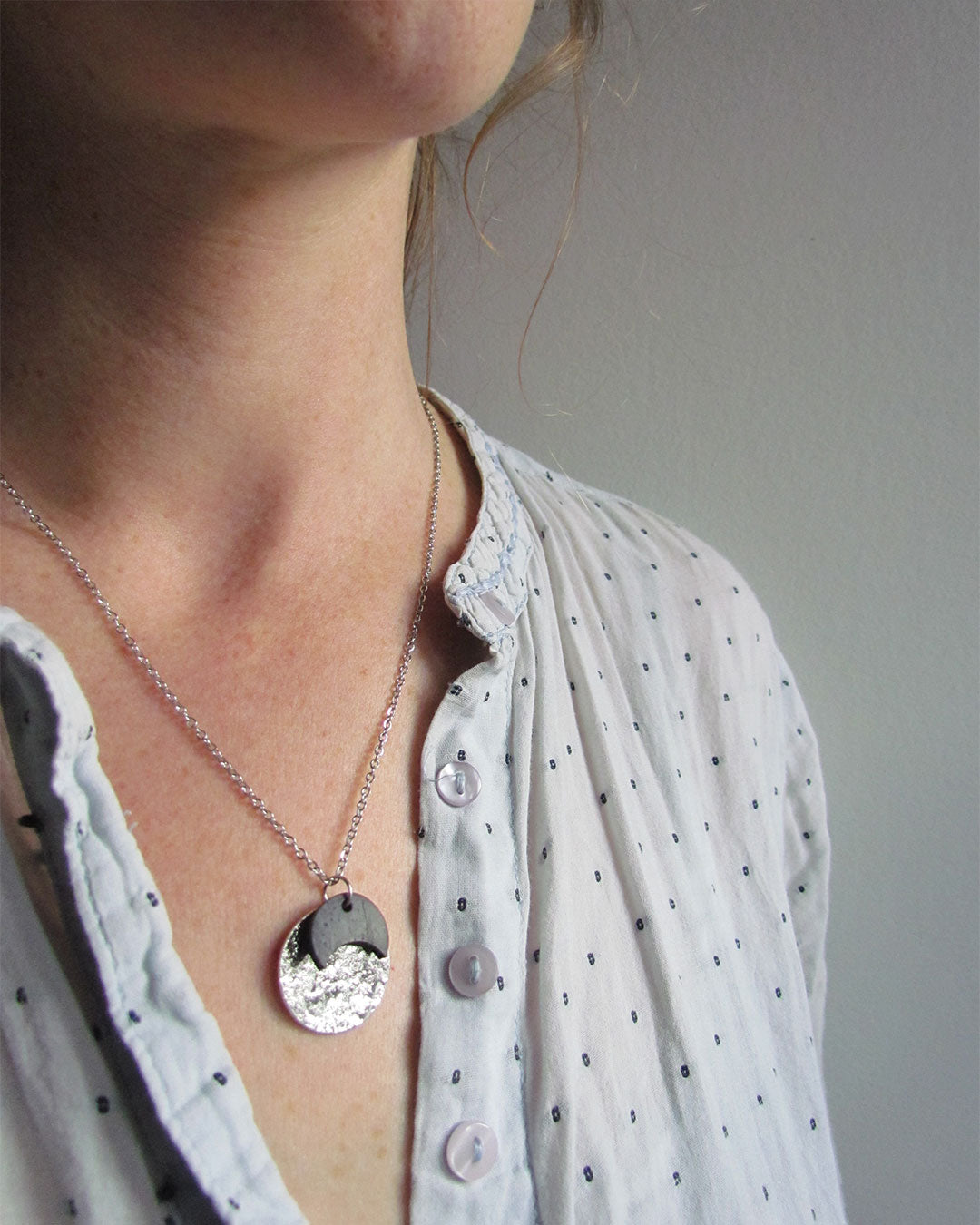 Collier comme une petite médaille argentée et noir