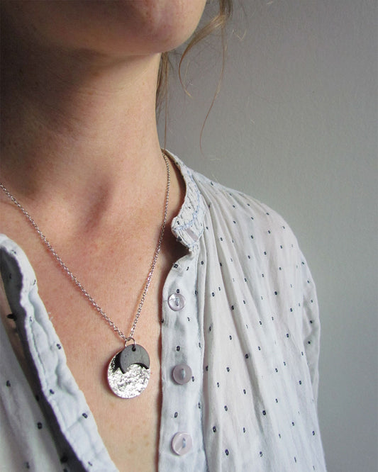 Collier comme une petite médaille argentée et noir